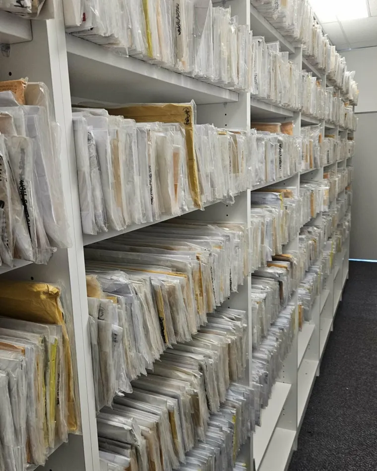 Shelving in the firm's access-controlled safe custody room, holding client documents in protective sleeves